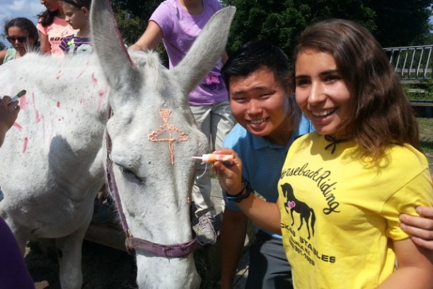 Group of children smiling at camera with horse in the picture