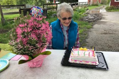 a little girl sitting at a table with a birthday cake