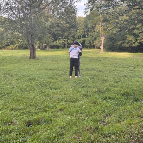 a group of people playing frisbee in a grassy field