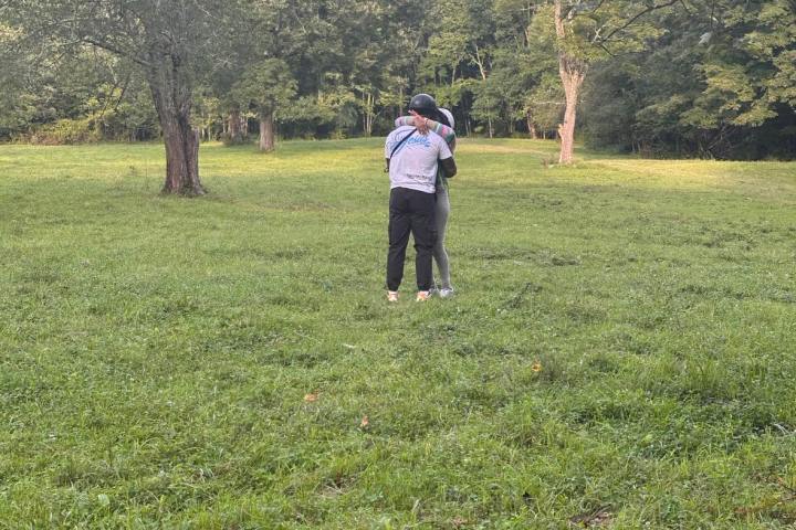 a group of people playing frisbee in a grassy field