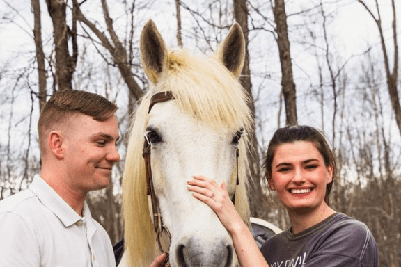 a group of people standing next to a horse