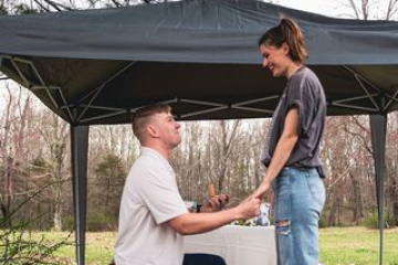 a man standing next to a tree