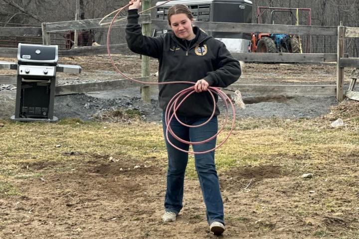 a young girl jumping on a dirt field