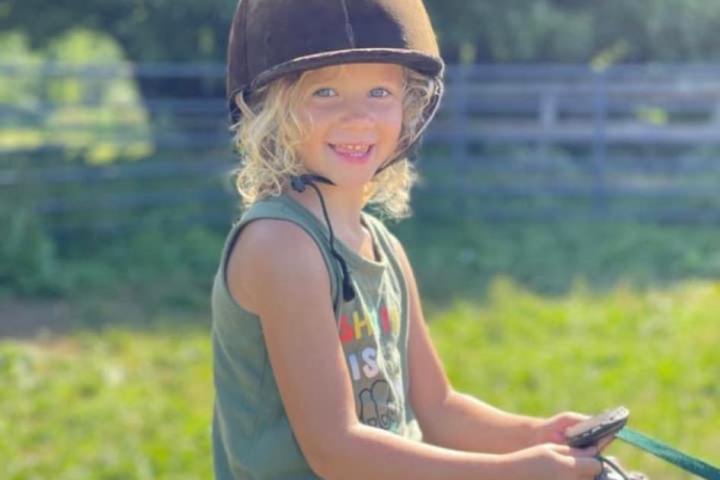 a little girl that is sitting in the grass