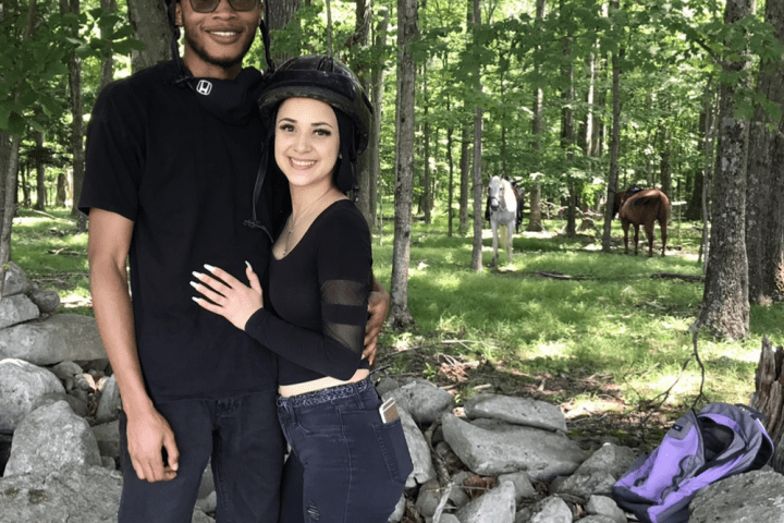 a man and a woman standing next to a tree