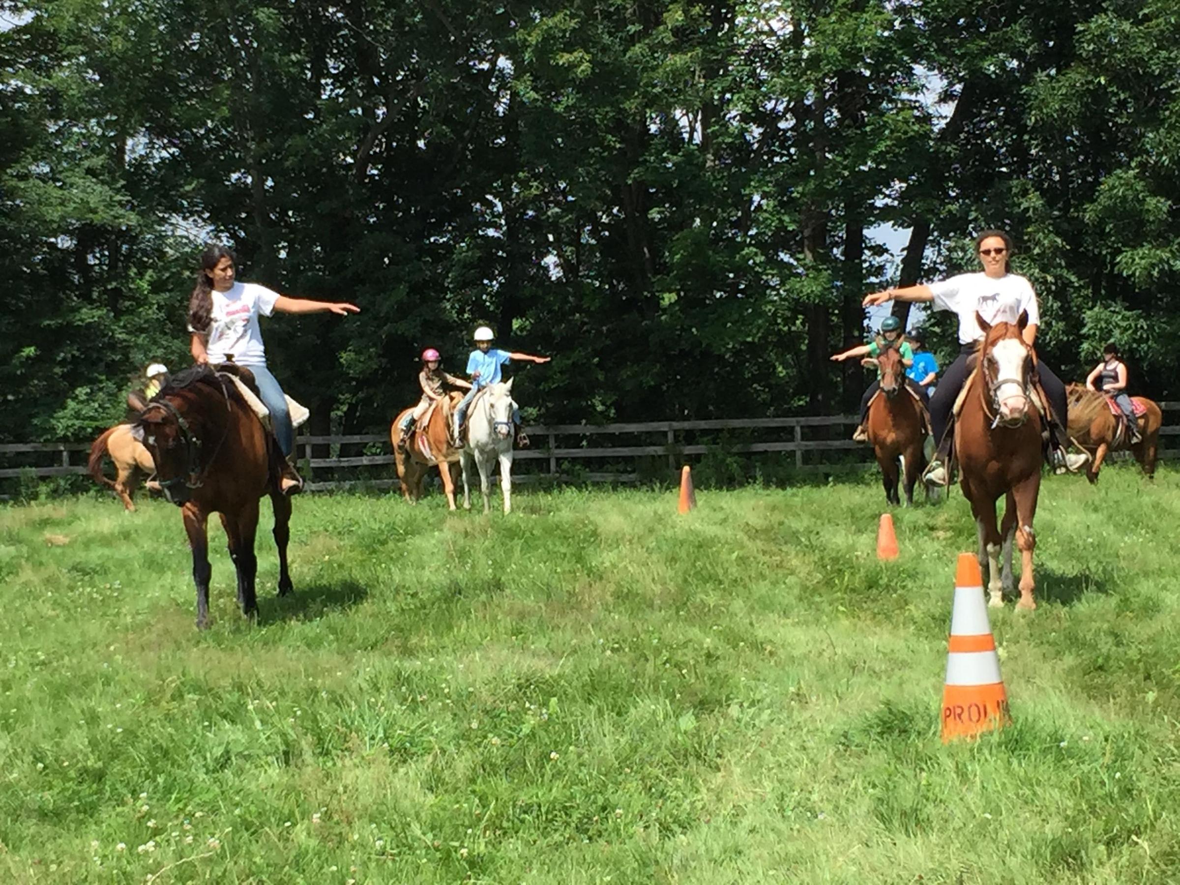 a group of people riding on the back of a horse in a field