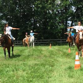 a group of people riding on the back of a horse in a field