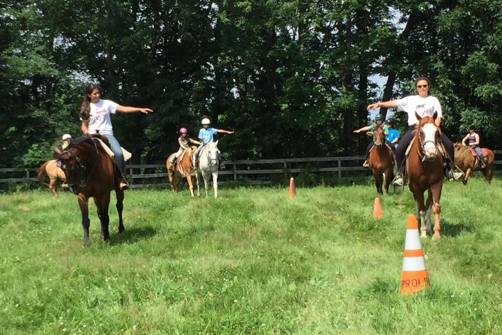 a group of people riding on the back of a horse in a field