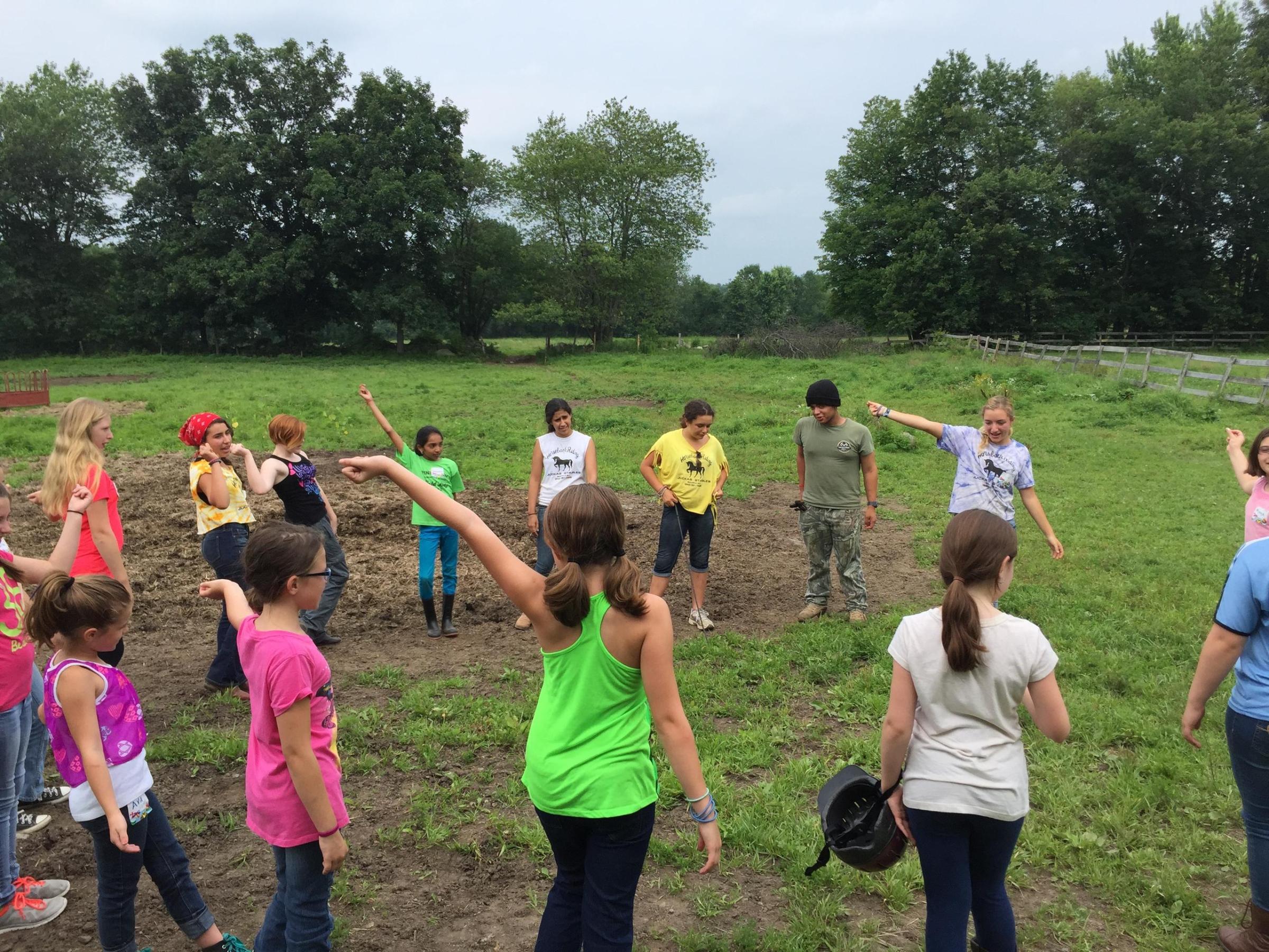 a group of people standing on top of a grass covered field