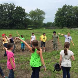 a group of people standing on top of a grass covered field