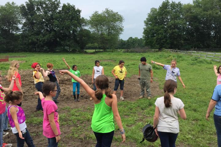 a group of people standing on top of a grass covered field