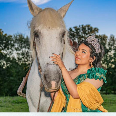 a young girl standing next to a horse