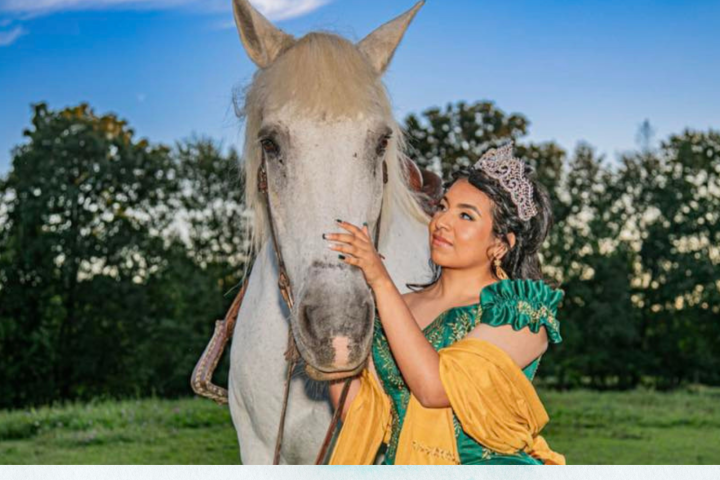 a young girl standing next to a horse