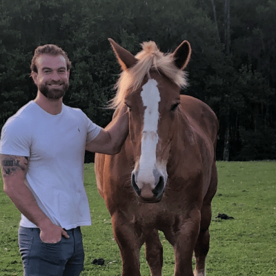 a man standing next to a horse