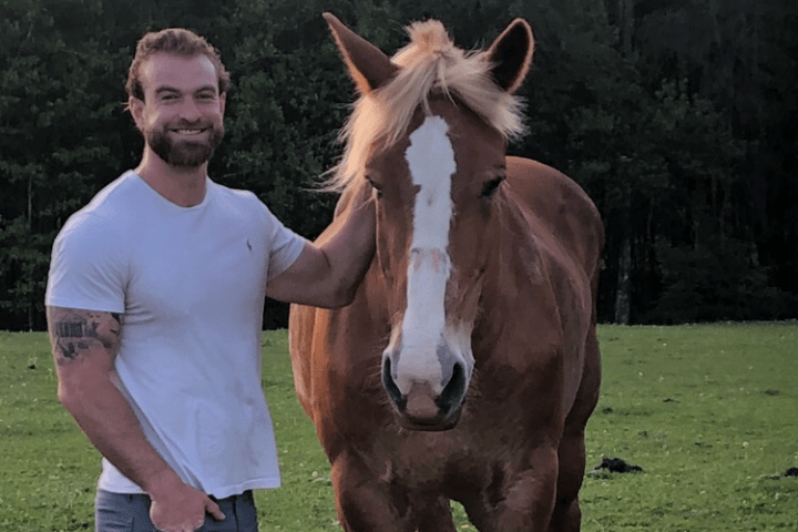 a man standing next to a horse