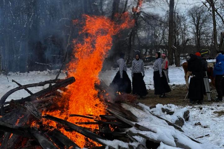 a group of people riding skis across snow covered ground