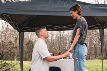 a man standing next to a tree