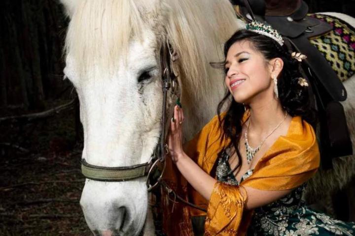 a woman standing next to a horse