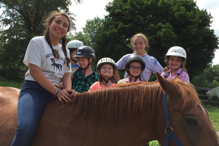 a group of people riding on the back of a brown horse
