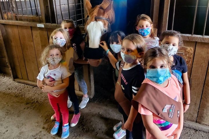 a group of young children standing next to a little girl