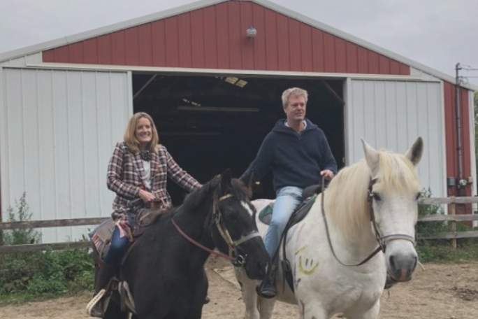 a couple of people that are standing in front of a horse