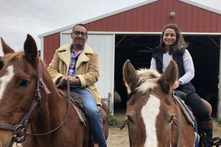 a group of people standing in front of a horse
