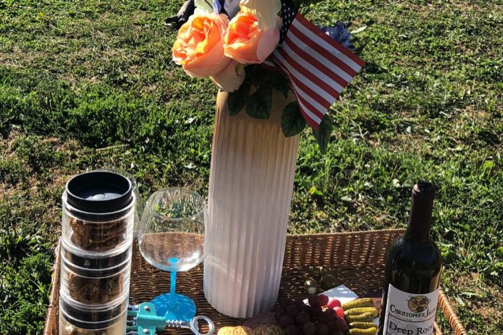 a bottle of wine sitting on top of a picnic table