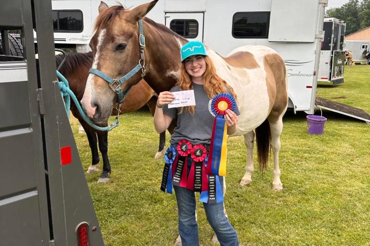 a group of people standing next to a horse