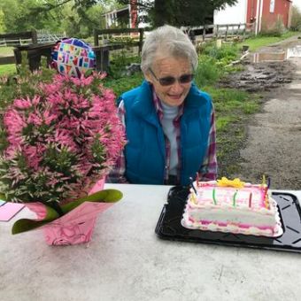a little girl sitting at a table with a birthday cake
