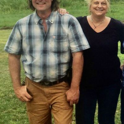 a group of people standing in a grass field posing for the camera