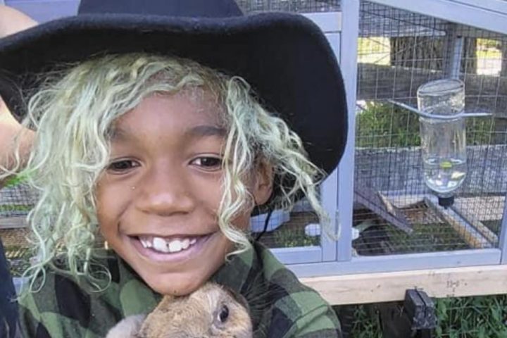 a little boy that is standing in the grass